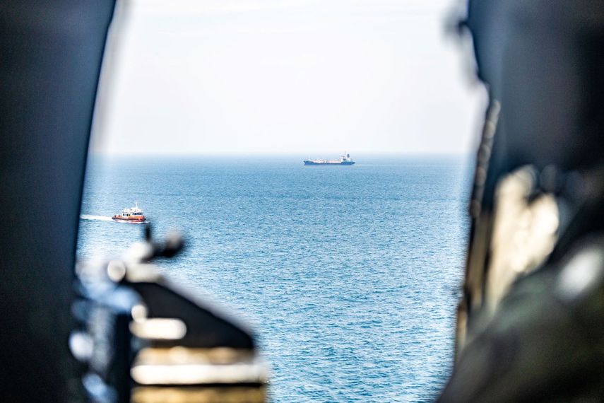 Un helicóptero del Ejército de EEUU observa el tránsito de buques comerciales mientras sobrevuela aguas regionales cerca del Estrecho de Ormuz durante el operativo de bloqueo marítimo contra Irán.