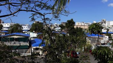 Casas afectadas por el paso de los huracanes permanecen con sus techos cubiertos por toldos en el barrio Santurce de San Juan, Puerto Rico.