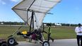 Fotografía proporcionada por la Oficina del Sheriff del condado de Monroe a través de la Florida Keys News Bureau, en la que aparecen empleados del aeropuerto internacional de Key West junto a un ala delta motorizada que aterrizó ilegalmente en el aeropuerto con dos hombres cubanos el sábado 25 de marzo de 2023 en Key West, Florida.&nbsp; &nbsp;