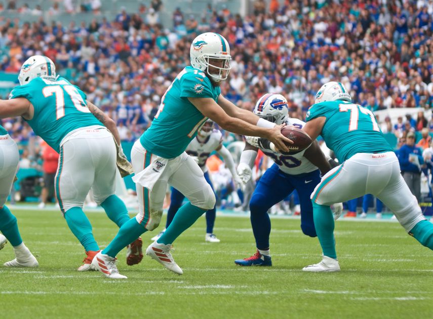 Ryan Fiztpatrick, quarterback de los Dolphins, entrega el ovoide a un jugador de su equipo contra&nbsp;los Buffalo Bills, la tarde del domingo en el Hard Rock Stadium.&nbsp;