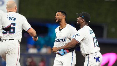 Peloteros de los Marlins de Miami corren al campo para felicitar al dominicano Otto López tras empujar la carrera de la ventaja en la novena entrada ante los Cardenales de San Luis, el miércoles 19 de junio del 2024.