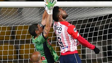 El portero argentino de Coquimbo de Chile, Matías Cano (izq.), Y el junior de Colombia, Miguel Angel Borja, compiten por el balón durante su partido de fútbol de cuartos de final de la Copa Sudamericana en el estadio Bicentenario Francisco Sánchez Rumoroso en Coquimbo, Chile, el 16 de diciembre de 2020.