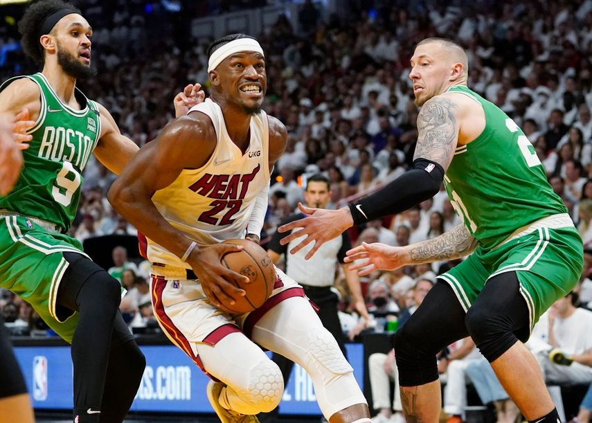 El alero del Miami Heat Jimmy Butler (22) empuja hacia la canasta entre el escolta de los Boston Celtics Derrick White (9) y el centro Daniel Theis (27) durante la segunda mitad del Juego 1 de una serie de playoffs de la final de la Conferencia Este de baloncesto de la NBA