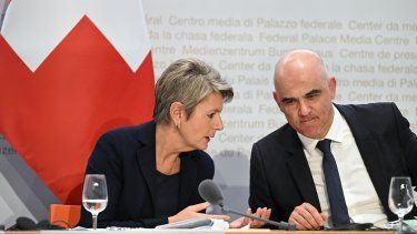 La ministra de Finanzas de Suiza, Karin Keller-Sutter (L), habla con el presidente de Suiza, Alain Berset, mientras asisten a una conferencia de prensa después de las conversaciones sobre la adquisición de UBS de su rival, el banco suizo Credit Suisse, en Berna el 19 de marzo de 2023.