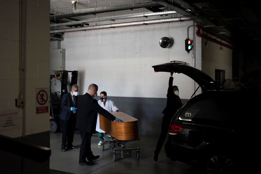 Empleados de la casa funeraria Sancho de &Aacute;vila de Barcelona se preparan para transportar un cad&aacute;ver el 14 de abril del 2020. Desde que se declar&oacute; un estado de emergencia por el coronavirus las funerarias espa&ntilde;olas deben seguir estrictos protocolos y depositan los cad&aacute;veres en los f&eacute;retros sin sacarlos de las bolsas en que llegaron.&nbsp;
