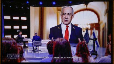 El presidente de Francia, Emmanuel Macron (izq.), habla mientras en la pantalla de fondo se muestra una foto del primer ministro israelí, Benjamin Netanyahu, durante una entrevista en vivo en los estudios de televisión en Saint-Denis, al norte de París, el 13 de mayo de 2025.