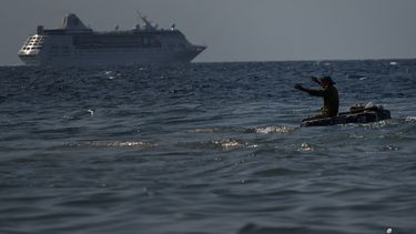 Un hombre pesca en una balsa improvisada mientras&nbsp;un crucero&nbsp;se aleja del puerto en La Habana, Cuba, el 5 de junio de 2019.