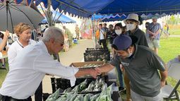 El embajador de Estados Unidos en Japón, Rahm Emanuel, saluda a un vendedor local en el mercado de agricultores de Camp Hansen, una base del Cuerpo de Marines de EEUU, en la isla de Okinawa, en el sur de Japón, el domingo 30 de octubre de 2022. Embajada de EEUU vía AP)