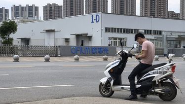 Un joven revisa su tel&eacute;fono frente a la f&aacute;brica OFILM de Nanchang, al este de China, que abastece a grandes empresas tecnol&oacute;gicas, incluidas Apple y Lenovo, el 5 de junio del 2019. La AP comprob&oacute; que numerosos miembros de la minor&iacute;a &eacute;tnica uigur son sometidos all&iacute; a trabajos forzados en el marco de los esfuerzos del gobierno chino por asimilarlos a la cultura dominante, la han.&nbsp;