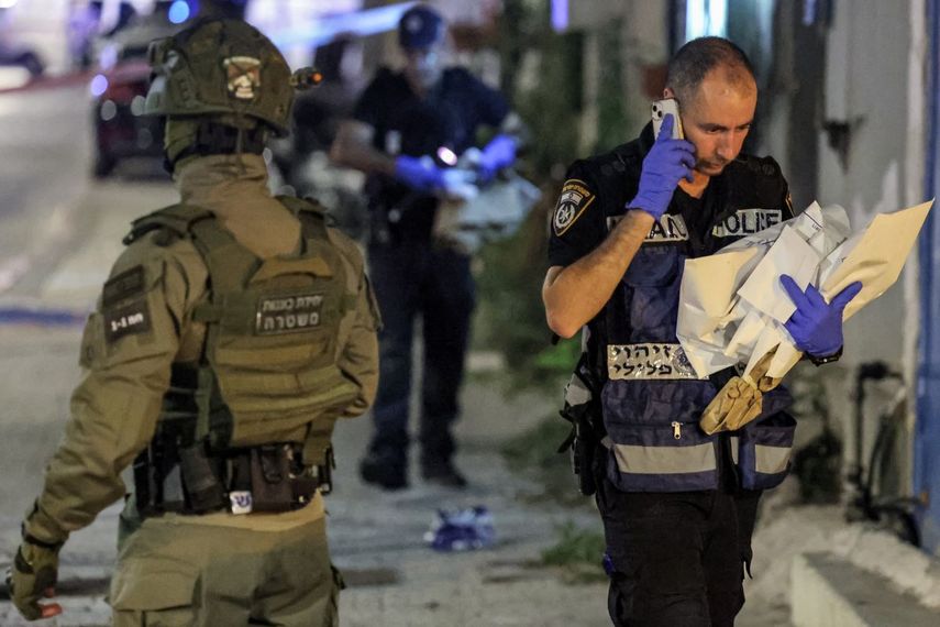 Un miembro del departamento forense de la policía israelí pasa junto a un miembro de las fuerzas especiales en el lugar de un ataque a tiros en Jaffa, al sur de Tel Aviv, el 1 de octubre de 2024. Al menos cuatro personas murieron a tiros el 1 de octubre en un presunto ataque en el centro de Israel, ciudad de Tel Aviv, dijo la policía, añadiendo que los dos agresores habían sido neutralizados.&nbsp;