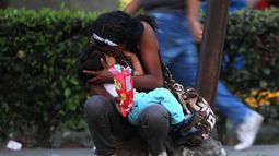 Una mujer venezolana abraza a su hijo en una acera de Colombia mientras espera para seguir su camino hacia Perú.&nbsp;