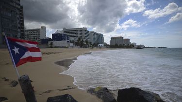 Una bandera de Puerto Rico ondea en una playa vacía en Ocean Park, el jueves 21 de mayo de 2020, en San Juan. 