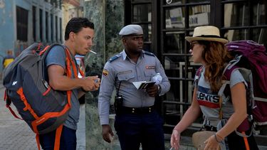 Un policía sostiene los pasaportes de dos turistas en La Habana, Cuba, luego del confinamiento obligatorio dictado por el régimen ante la propagación del coronavirus COVID-19.