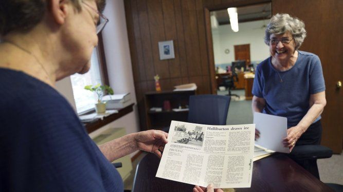 Las monjas Rose Marie Stallbaumer (i) y Barbara McCracken (d) examinan propuestas para resoluciones corporativas y artículos de prensa en el convento Mount St. Scholastica en Atchison, Kansas, el 16 de julio del 2024.