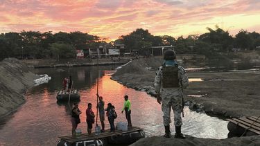 Un miembro de la Guarda Nacional de M&eacute;xico mira mientras residentes cruzan el r&iacute;o Suchiate, cerca de Ciudad Hidalgo, en la frontera con Guatemala, el 17 de enero de 2020.&nbsp;