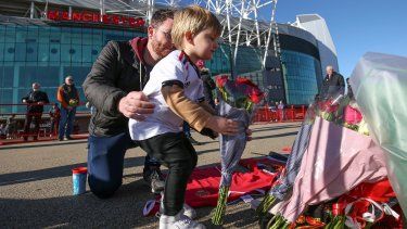 Un niño coloca flores en memoria a Bobby Charlton a los pies de la estatua The United Trinity en las afueras de Old Trafford, estadio del Manchester United el domingo 22 de octubre del 2023.&nbsp;