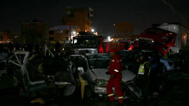 Un agente de policía y equipos de rescate caminan junto a vehículos destruidos cerca del lugar donde se estrelló un avión militar en El Alto, cerca de La Paz, el 27 de febrero de 2026.