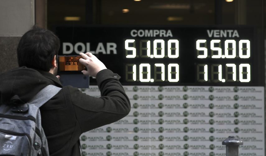Un hombre toma una foto de una pizarra en una casa de cambio de divisas en Buenos Aires, Argentina, el lunes 12 de agosto de 2019.&nbsp;&nbsp;