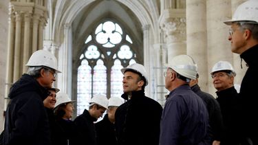 El presidente francés, Emmanuel Macron, con un casco de trabajo, habla con expertos en conservación mientras visita el sitio de restauración en la catedral de Notre-Dame de París, que resultó dañada en un devastador incendio hace cuatro años, el 14 de abril de 2023.