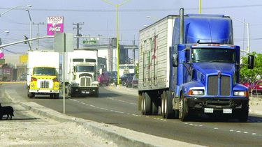 Camiones de carga viajan por el bulevar hacia la frontera Estados Unidos y México, en Tijuana.