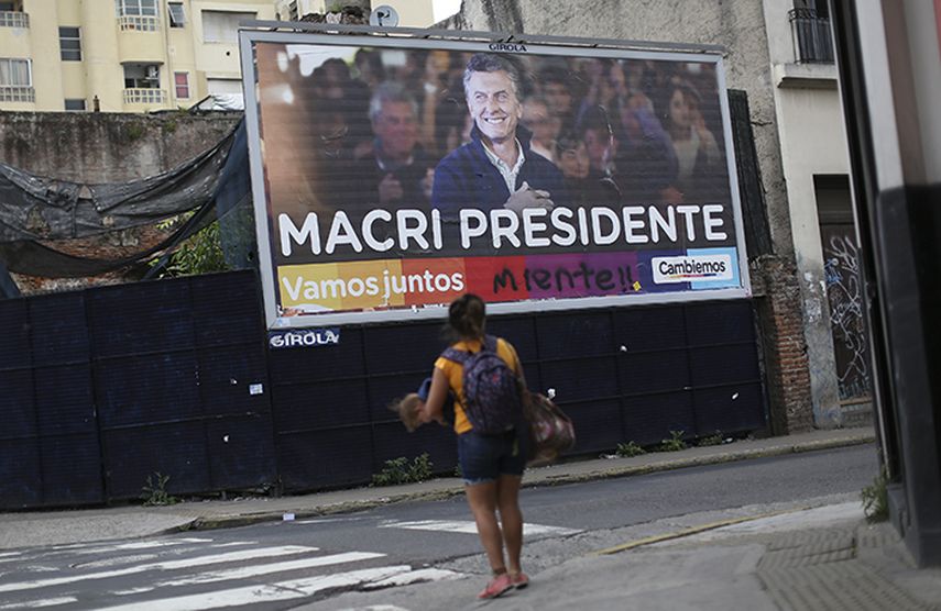 Una mujer camina frente a una valla de propaganda electoral del conservador Mauricio Macri en el centro de Buenos Aires. (EFE)