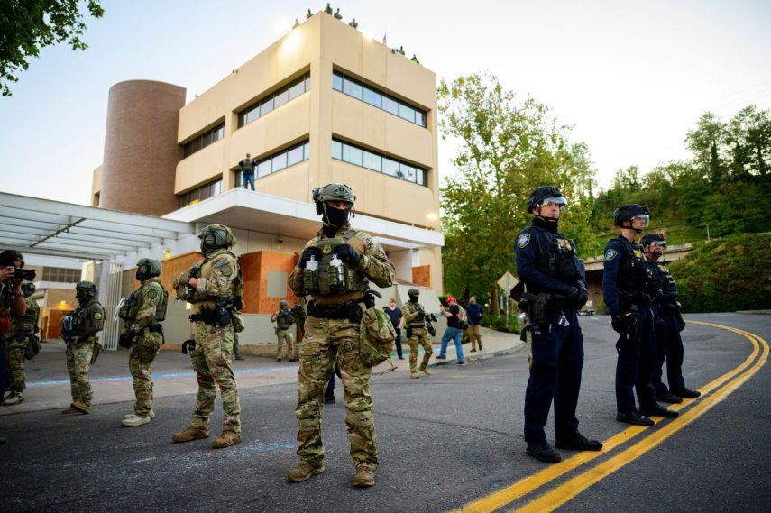 Agentes federales, incluidos miembros del Departamento de Seguridad Nacional, ICE y otros, custodian una instalación de Inmigración y Control de Aduanas (ICE) en el centro de Portland, Oregón, ante la amenaza de manifestantes proinmigración indocumentada.