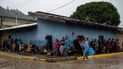 Migrantes llegados a la zona sur de Honduras con destino a Estados Unidos, se protegen de la lluvia.
