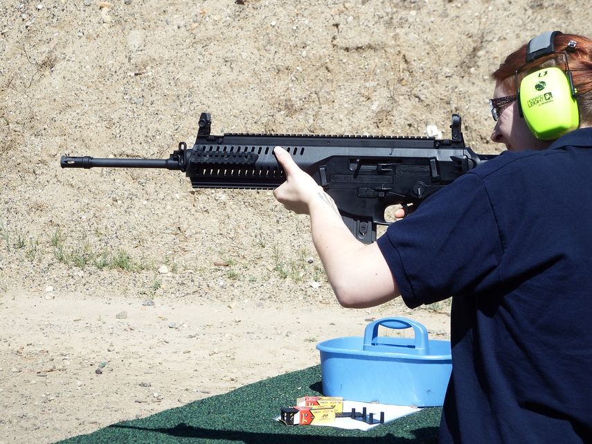Imagen referencial a una mujer apuntando con un rifle