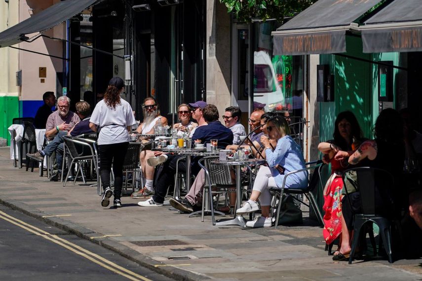 Personas disfrutan un día soleado en un restaurante en Soho, Londres,