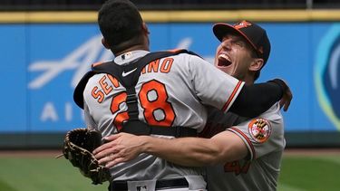 El abridor de los Orioles de Baltimore, John Meansabraza al receptor Pedro Severino después de que lanzara un juego sin hits