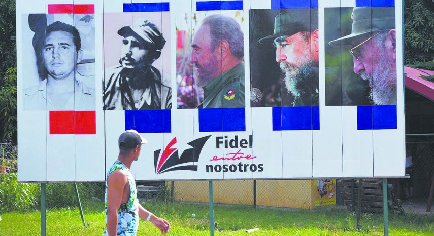 Una hombre pasa frente a una valla propagandística en una calle de La Habana.