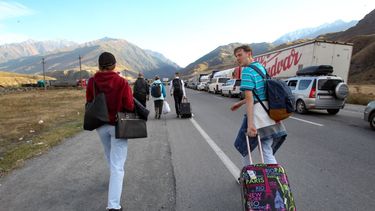 Gente camina hacia el cruce fronterizo en Verkhny Lars entre Georgia y Rusia, el miércoles 28 de septiembre de 2022. Miles de personas se han ido de Rusia después de que Moscú anunciara una movilización militar para reforzar sus tropas en Ucrania.