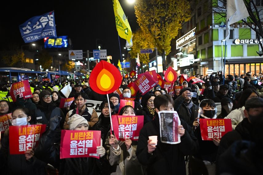 Los manifestantes que participan en una marcha contra el presidente de Corea del Sur, Yoon Suk Yeol, se dirigen a la oficina presidencial en Seúl el 4 de diciembre de 2024. Miles de manifestantes marcharon hacia la oficina de Yoon en la capital de Corea del Sur en la tarde del 4 de diciembre, uniéndose a la campaña de la oposición del país para destituir al líder después de su extraordinaria pero efímera imposición de la ley marcial.&nbsp;