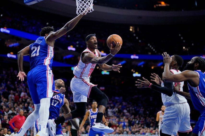 Jimmy Butler del Heat de Miami avanza hacia la canasta mientras lo defiende Joel Embiid de los 76ers de Filadelfia en el encuentro del lunes 27 de febrero del 2023.&nbsp;