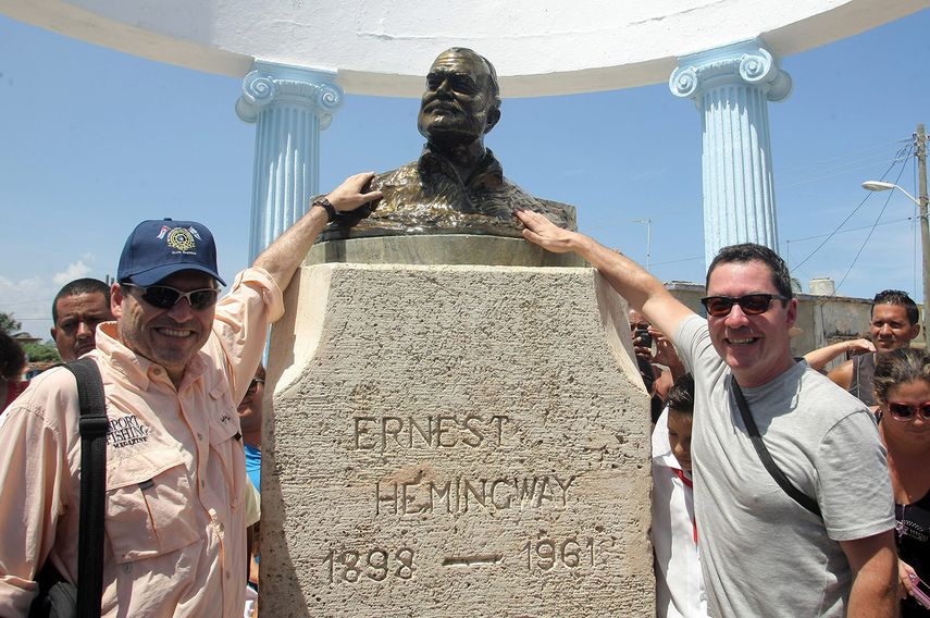 Los nietos del escritor estadounidense posan junto al busto de su abuelo. (EFE)