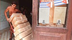 Un cubano manipula cajas en una farmacia local en el centro de La Habana, el 6 de julio de 1995, junto a una vitrina que exhibe fotografías y las biografías de dos candidatos municipales que aspiran a un cargo en las elecciones municipales del 9 de julio.&nbsp;