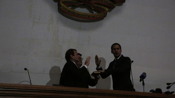 Sin energ&iacute;a el&eacute;ctrica, el l&iacute;der de la oposici&oacute;n Juan Guaid&oacute;, a la derecha, es juramentado como presidente de la Asamblea Nacional por el legislador Juan Pablo Guanipa en Caracas, Venezuela, el martes 7 de enero de 2020.