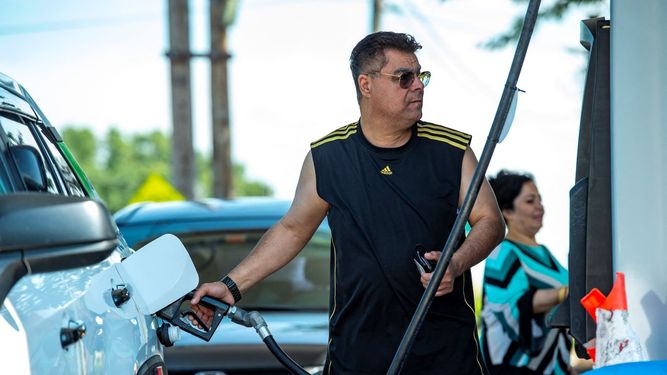 Un conductor repone gasolina en su auto.