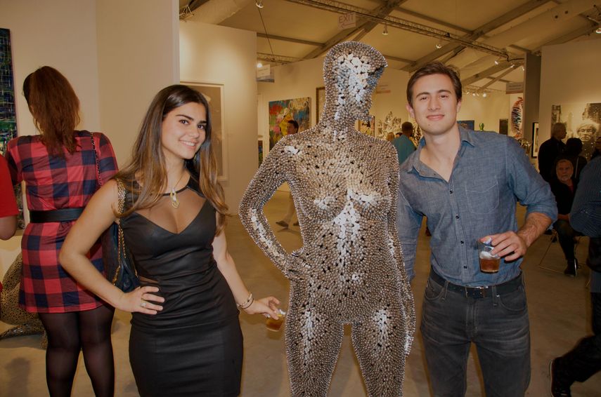 Tatiana Pernetti y Emilio Cubero posan junto a una de las piezas en exhibición en Art Wynwood.