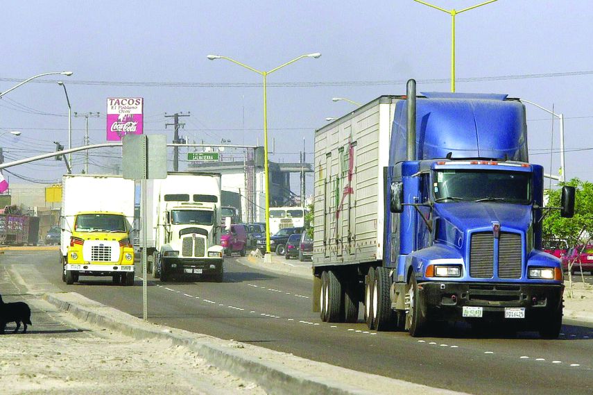 Camiones de carga viajan por el bulevar hacia la frontera Estados Unidos y México, en Tijuana.