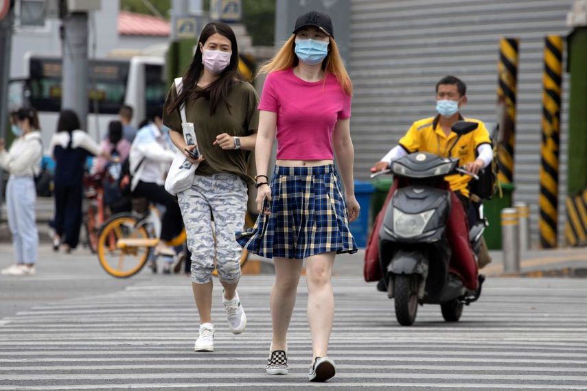 &nbsp; Varias personas que portan mascarillas para protegerse del coronavirus cruzan una avenida el mi&eacute;rcoles 17 de junio de 2020, en Pek&iacute;n. &nbsp;