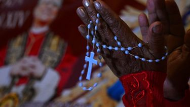Una mujer reza junto a la imagen de Robert Francis Prevost, quien se convirtió en el Papa León XIV el 8 de mayo de 2025, frente a la catedral de Chiclayo, en el norte de Perú, el día de su elección como el 267º pontífice de la Iglesia católica.