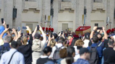 Cientos de personas observan la llegada del féretro del Papa Francisco I a la Basílica de San Pedro, a 23 de abril de 2025, en Ciudad del Vaticano.&nbsp;&nbsp;
