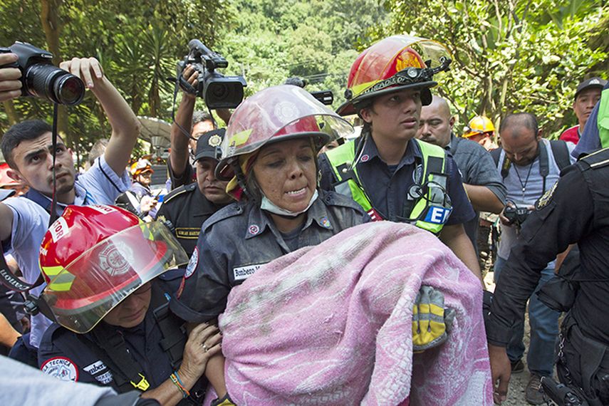 Una bombero rescata el cuerpo de una niña de tres años tras el deslizamiento de tierra en Guatemala (EFE)