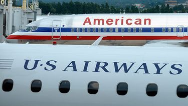 En esta imagen de archivo, un avión de American Airlines y otro de US Airways estacionados en el Aeropuerto Nacional Ronald Reagan de Washington. (Foto AP/Susan Walsh)