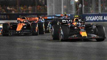 El piloto mexicano de Red Bull Racing, Sergio Pérez (R), conduce delante del piloto australiano de McLaren, Oscar Piastri (L), durante la carrera nocturna del Gran Premio de Fórmula 1 de Singapur en el Marina Bay Street Circuit de Singapur el 17 de septiembre de 2023. &nbsp; &nbsp;