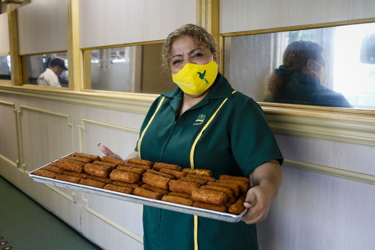Un empleado sostiene una bandeja con croquetas cubanas durante el 50 aniversario del Restaurante Versailles en Miami, Florida, el 10 de noviembre de 2021. 