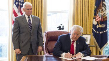 Donald Trump firmando el 19MAR18 una orden ejecutiva prohibiendo transacciones con criptomonedas emitidas por el régimen chavista. A su lado, el exvicepresidente Mike Pence.&nbsp;