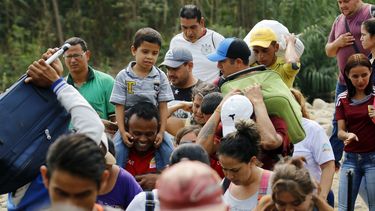 Un grupo de venezolanos cruza con sus pertenencias hacia territorio de Cúcuta,&nbsp;Colombia, atravesando un río debido al cierre de los pasos fronterizos.