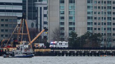 Los patines de aterrizaje de un helicóptero (derecha) se ven en el agua junto a una lancha de la policía de Nueva York frente a la costa de Hoboken, Nueva Jersey, desde Nueva York, tras estrellarse en el río Hudson el 10 de abril de 2025.&nbsp;